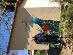 Donatella-CinelliColombini-davanti-al-murales-della-cantina-della-Fattoria-del-Colle-con-la-gamba-rotta
